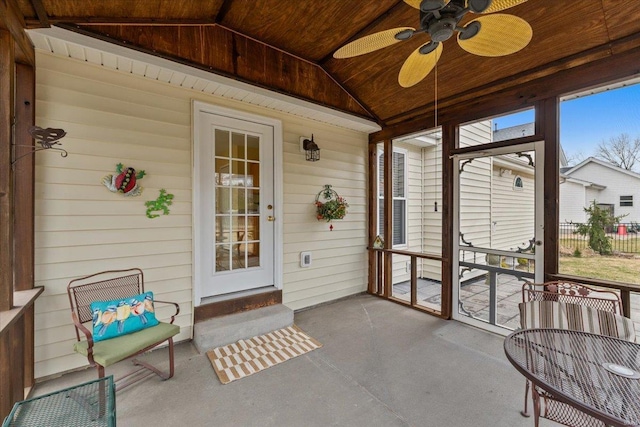 sunroom / solarium with lofted ceiling, wood ceiling, and a ceiling fan