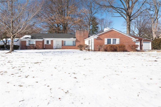 ranch-style home with a garage, a chimney, and brick siding