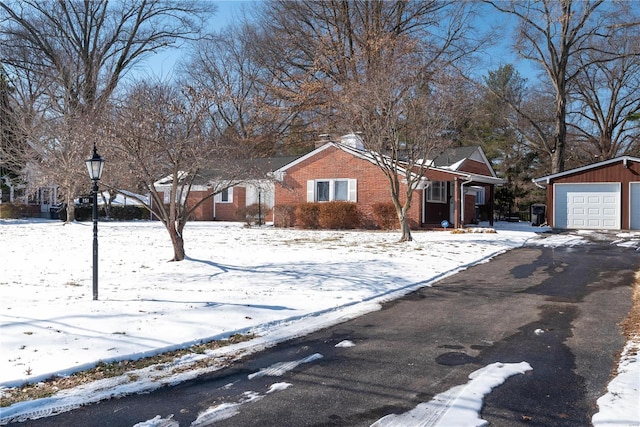 view of front of home with a garage, brick siding, and aphalt driveway