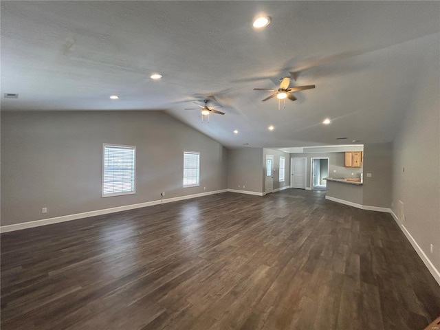 unfurnished living room featuring lofted ceiling, baseboards, dark wood finished floors, and a ceiling fan