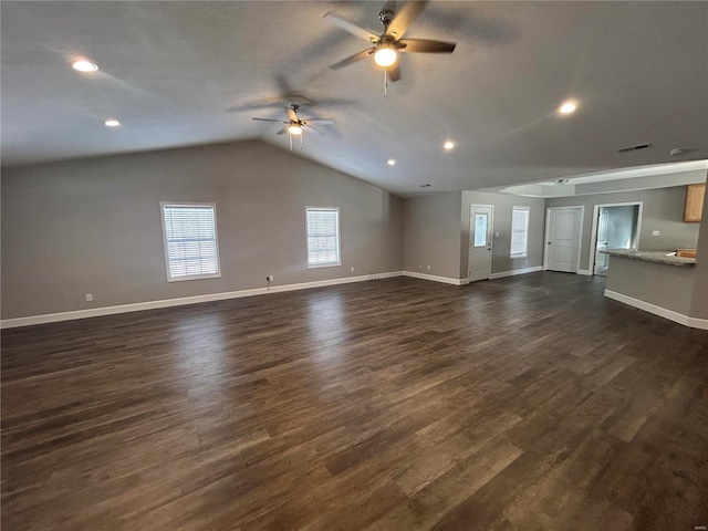 unfurnished living room featuring dark wood-style flooring, visible vents, vaulted ceiling, and baseboards