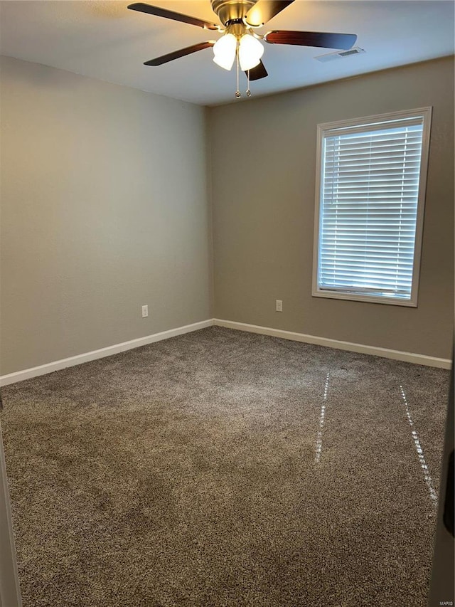 unfurnished room featuring visible vents, ceiling fan, and baseboards