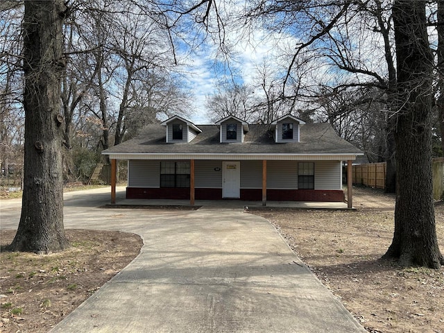 view of front of home featuring driveway, a porch, fence, and brick siding