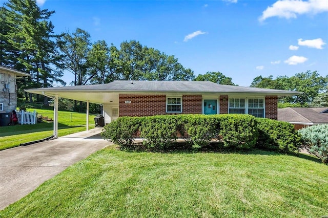 view of front facade featuring an attached carport, brick siding, driveway, and a front yard