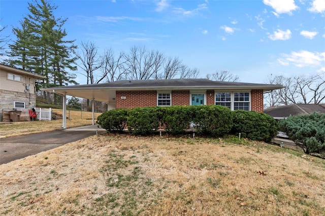 ranch-style house featuring a carport, brick siding, and driveway