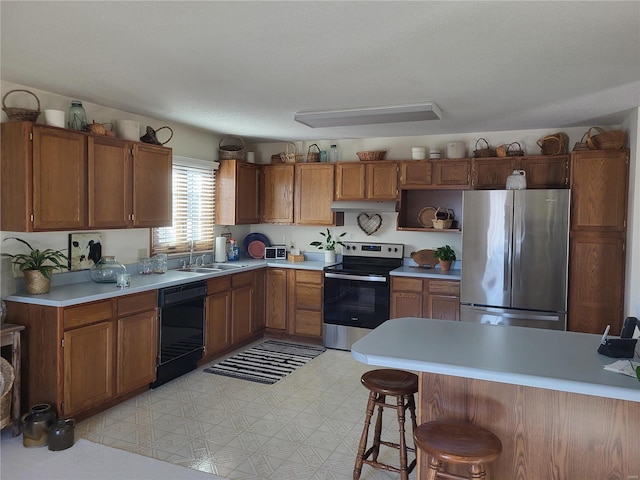 kitchen featuring brown cabinetry, stainless steel appliances, light countertops, under cabinet range hood, and a sink