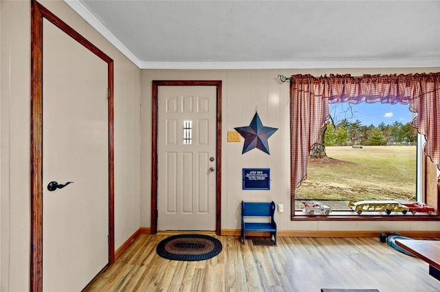 entryway with ornamental molding, wood finished floors, and baseboards