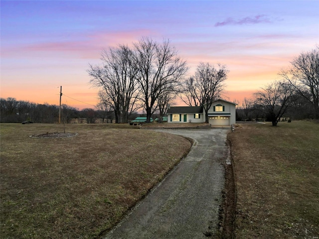 view of front of property with a garage, a front yard, and driveway