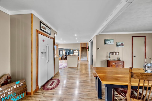 dining room featuring ornamental molding, a barn door, light wood-style flooring, and recessed lighting