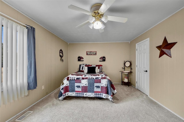 bedroom featuring carpet floors, visible vents, ceiling fan, and crown molding