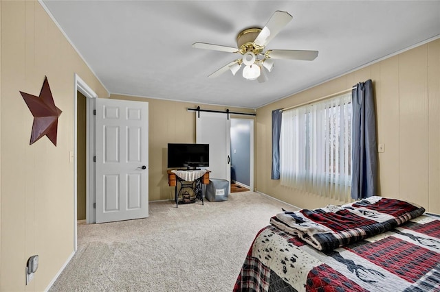 bedroom featuring a barn door, carpet, and a ceiling fan