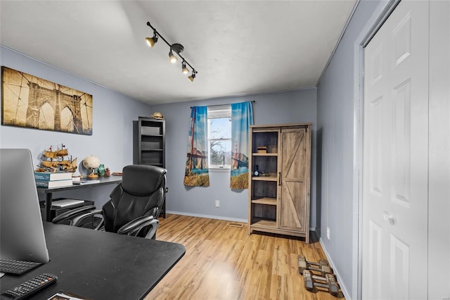 office area featuring rail lighting, baseboards, and wood finished floors