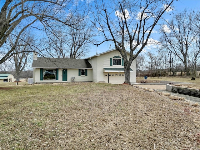 view of front facade featuring a garage, a front yard, and driveway