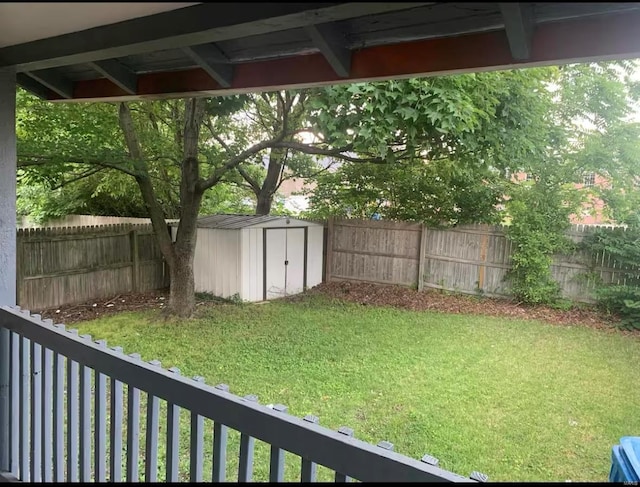 view of yard featuring a shed, a fenced backyard, and an outdoor structure