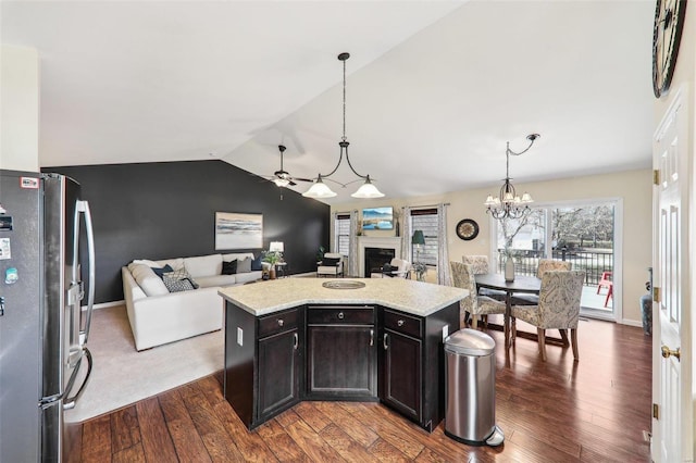 kitchen with a fireplace, open floor plan, dark wood-style flooring, and freestanding refrigerator