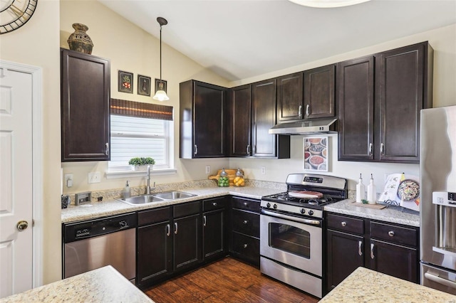 kitchen with appliances with stainless steel finishes, dark wood-type flooring, vaulted ceiling, under cabinet range hood, and a sink