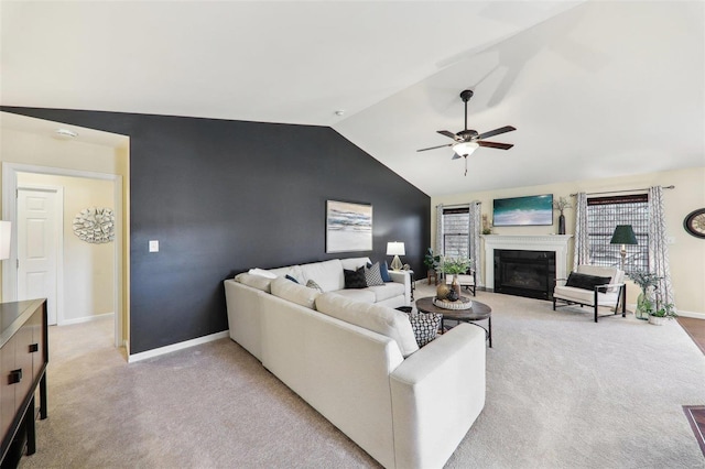 living room featuring light carpet, baseboards, a glass covered fireplace, ceiling fan, and vaulted ceiling