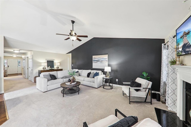 carpeted living area with lofted ceiling, an accent wall, a fireplace with flush hearth, a ceiling fan, and baseboards