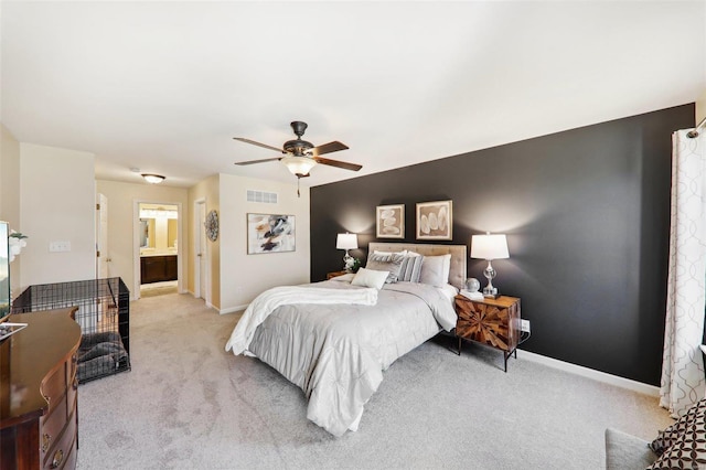 bedroom with light carpet, baseboards, visible vents, ensuite bath, and ceiling fan