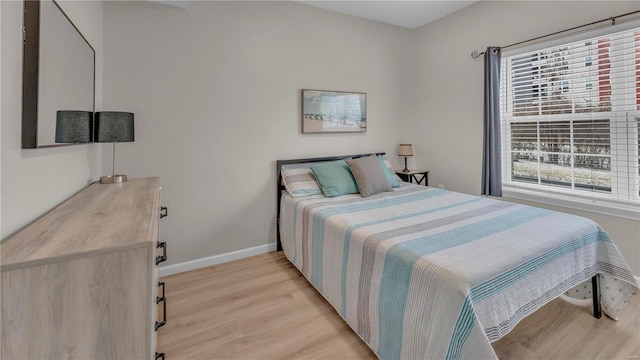 bedroom featuring light wood-style floors and baseboards