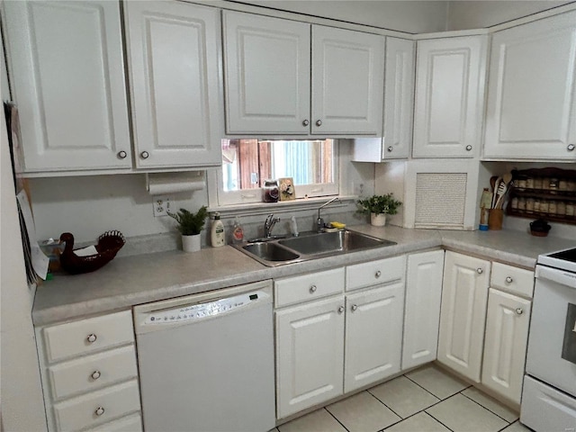 kitchen with white appliances, white cabinets, and a sink