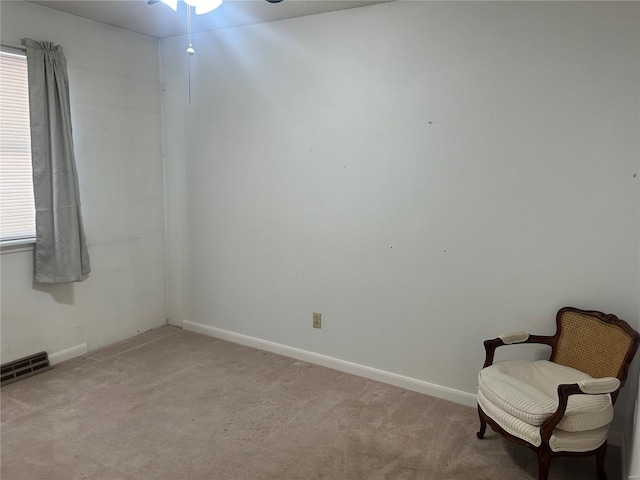 empty room with a wealth of natural light, visible vents, light carpet, and baseboards