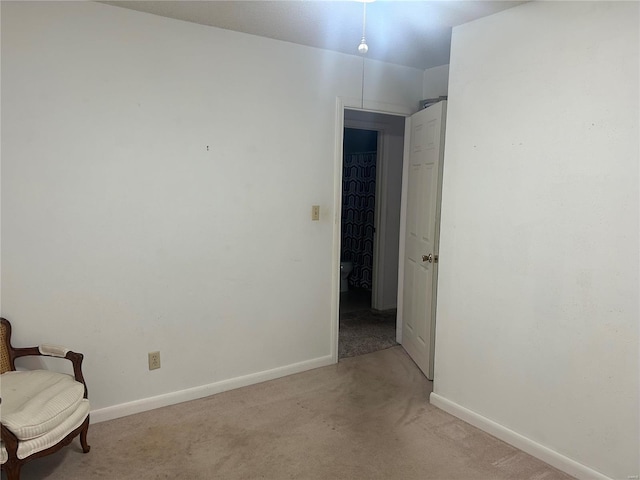 interior space featuring light carpet and baseboards