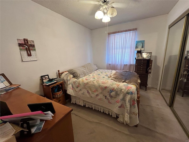 bedroom featuring a textured ceiling, a closet, a ceiling fan, and light colored carpet