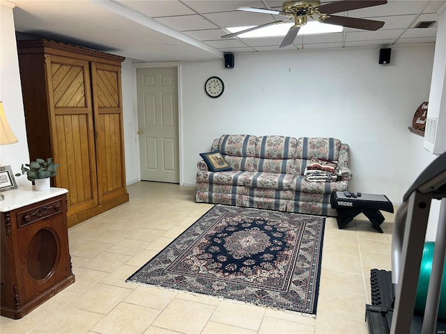 living area with ceiling fan, visible vents, and a drop ceiling