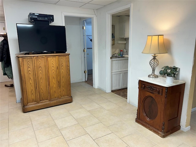 interior space with a paneled ceiling and baseboards