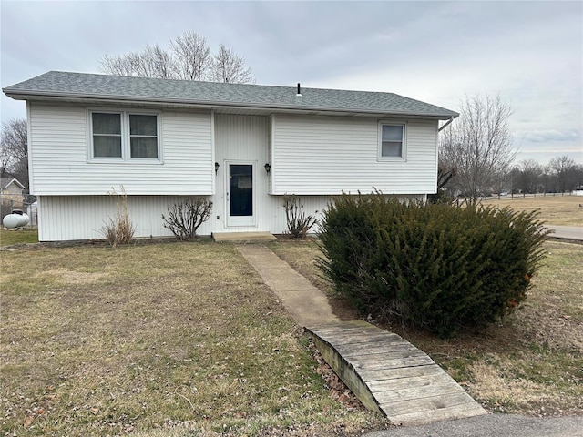 bi-level home with a shingled roof and a front yard