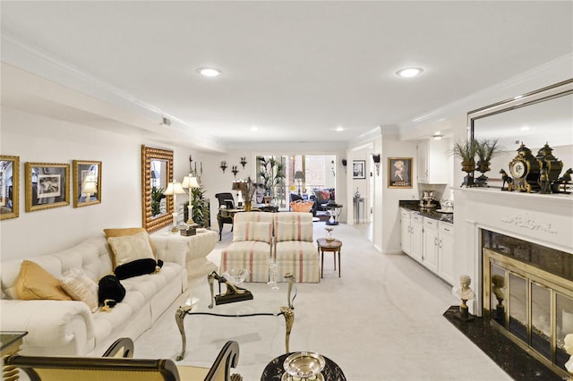 living area with recessed lighting, ornamental molding, light colored carpet, and a high end fireplace