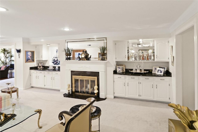 living room featuring recessed lighting, bar, a fireplace with flush hearth, and light colored carpet