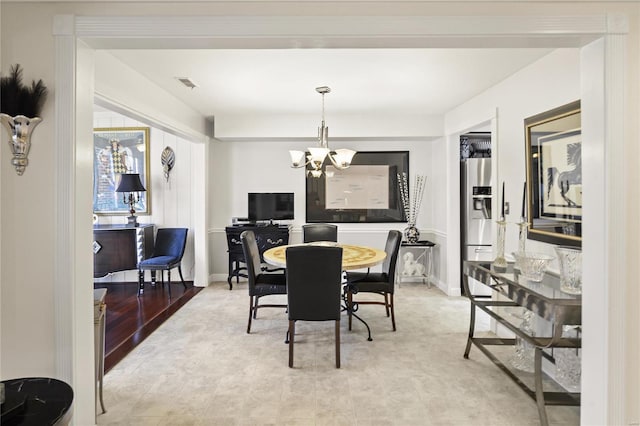 dining room with baseboards, visible vents, and a notable chandelier