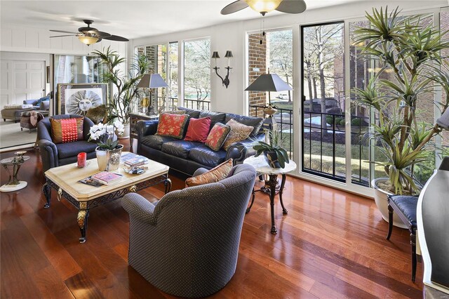 living area with a ceiling fan and wood finished floors