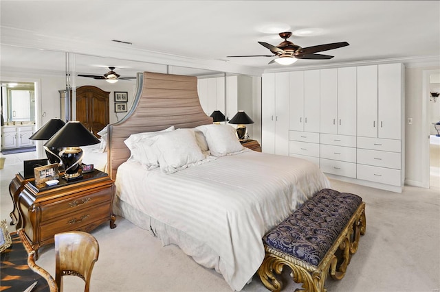 bedroom featuring light carpet, visible vents, connected bathroom, ceiling fan, and crown molding