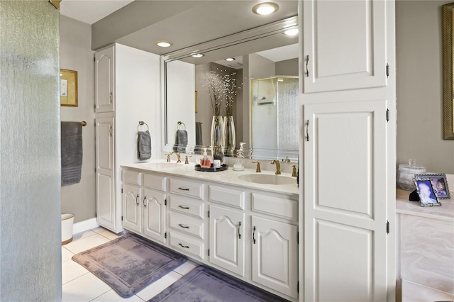 full bath featuring double vanity, a stall shower, a sink, and tile patterned floors