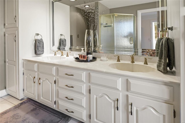 bathroom featuring double vanity, tile patterned floors, a sink, and a shower stall