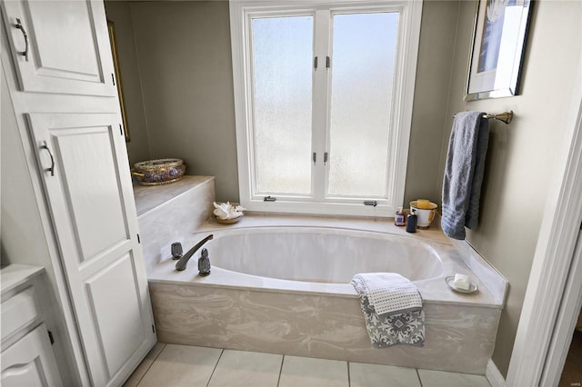 bathroom with a garden tub and tile patterned flooring