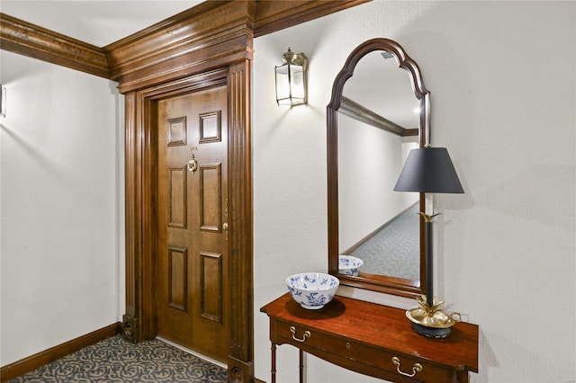 foyer entrance with ornamental molding and baseboards