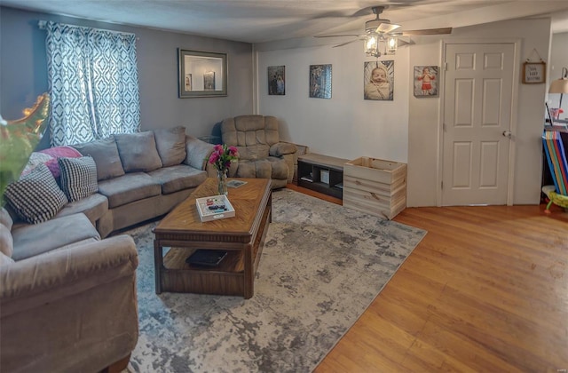 living room featuring a ceiling fan and wood finished floors