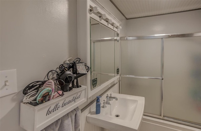 full bathroom featuring a sink and a shower with door