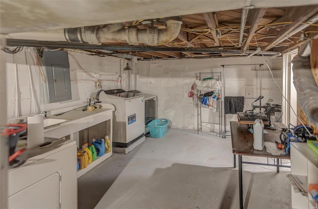 unfinished basement featuring electric panel and washer and dryer