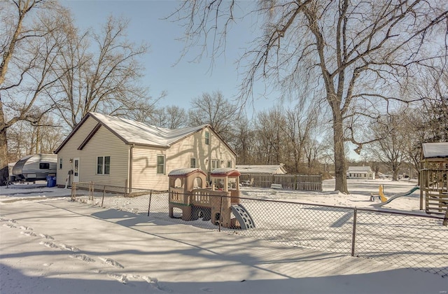 view of front of home with a playground and fence