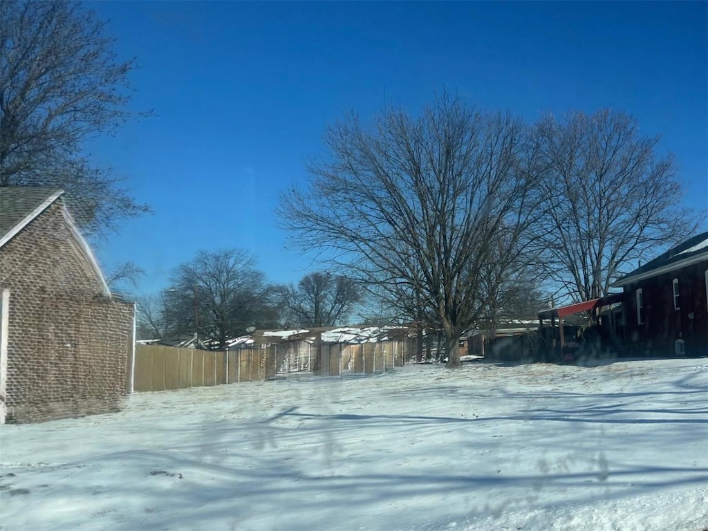 yard layered in snow with fence