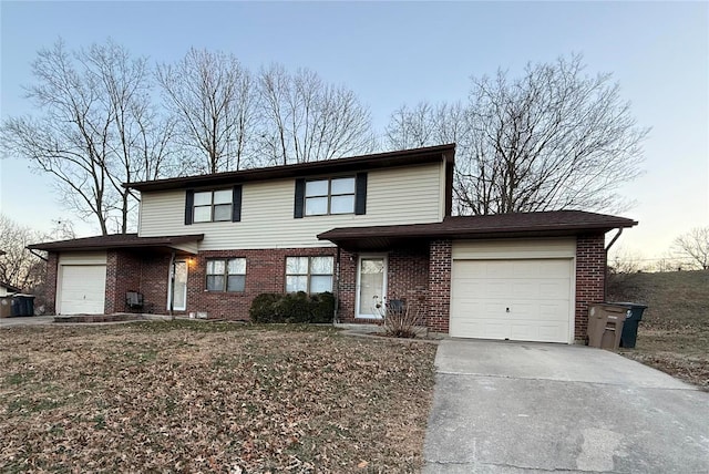 traditional-style house featuring concrete driveway, brick siding, and an attached garage