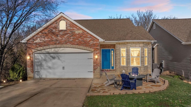 view of front facade featuring driveway, stone siding, roof with shingles, an attached garage, and brick siding