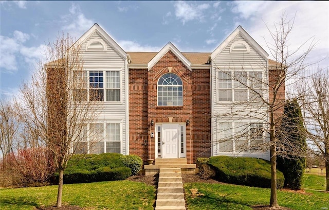 view of front of property featuring brick siding and a front lawn