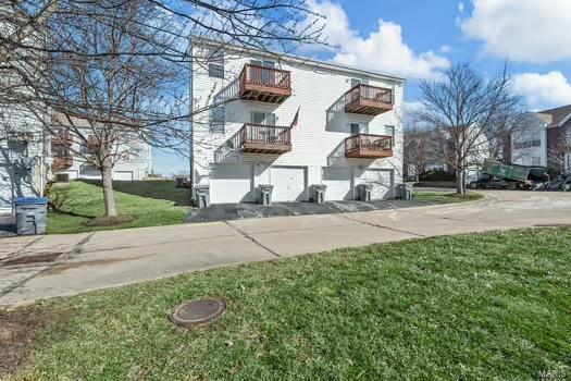 view of side of home with a lawn and a balcony