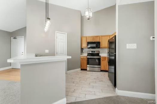 kitchen featuring light countertops, hanging light fixtures, black appliances, high vaulted ceiling, and baseboards